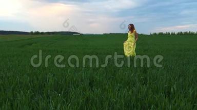 穿着黄色衣服的年轻漂亮女人穿着高草绿野